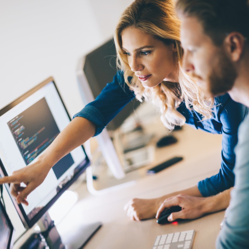 Un homme et une femme échangent sur un projet informatique
