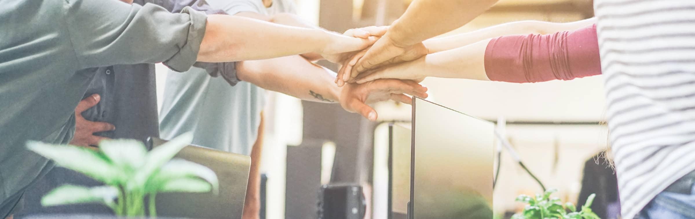 Une équipe de collaborateurs se tiennent les mains